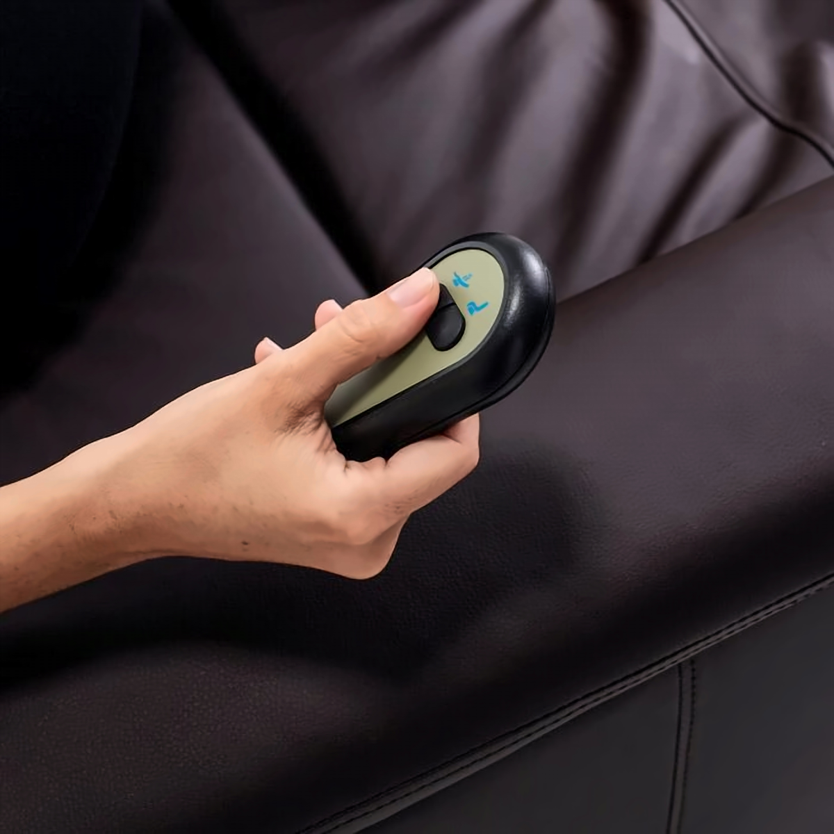 Mano usando el control de dos botones para cambiar la posición del sillón.
