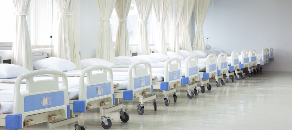 Sala de hospital con muchos catres clínicos